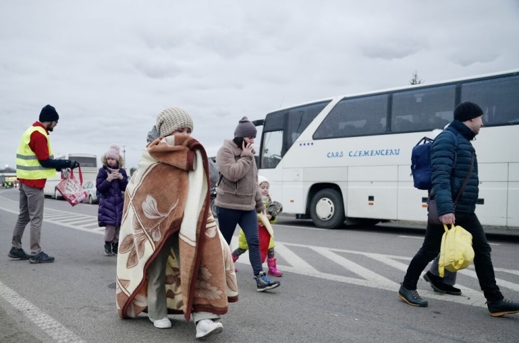 Flüchtlinge vor einem Bus