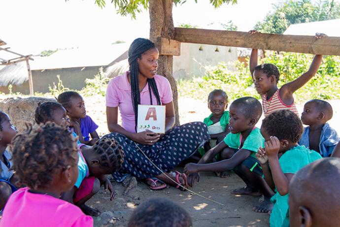 young woman teaching a group of students in Africa