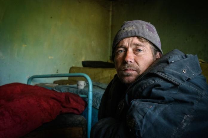 Mann in der Ukraine in einer kalten Behausung