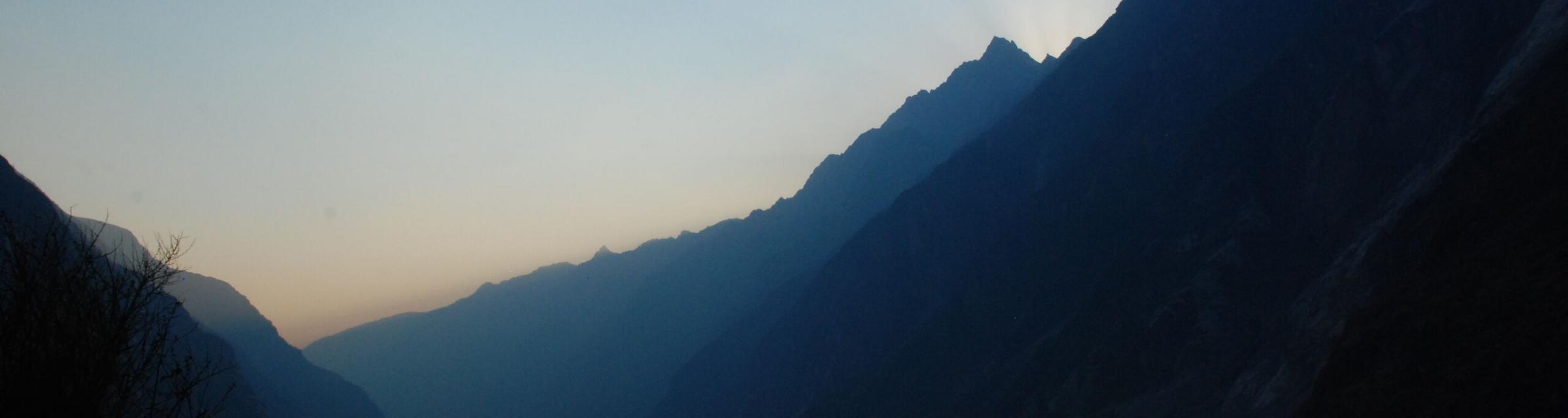 As the sun sets in the Himalayan Mountains, the sunrays peak over the top. Photo by Ellyn S.