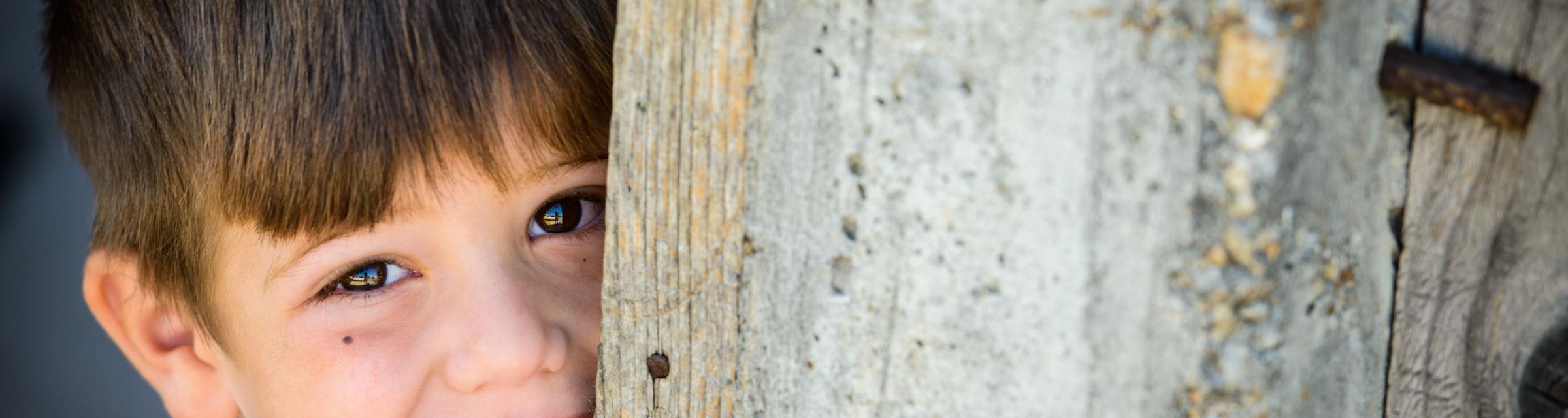 A young gypsy or roma boy shyly posses for his picture during a house church meeting in a Romanian gypsy village.