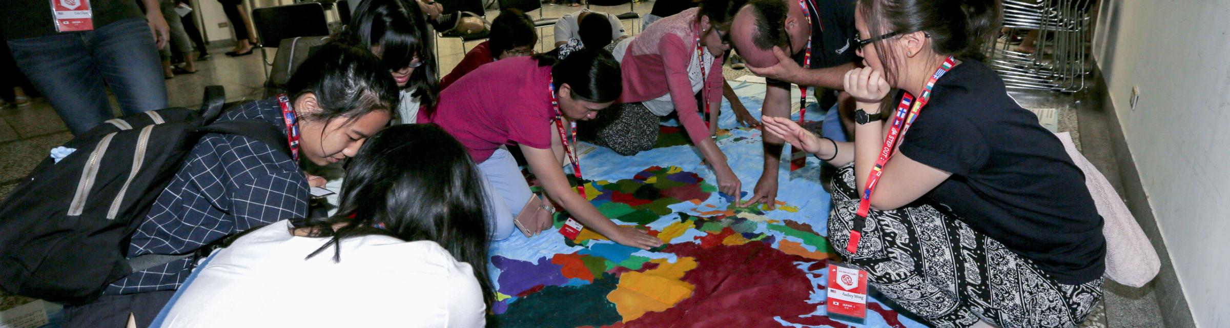 Step Out participants pray for the nations over the world map during the event.