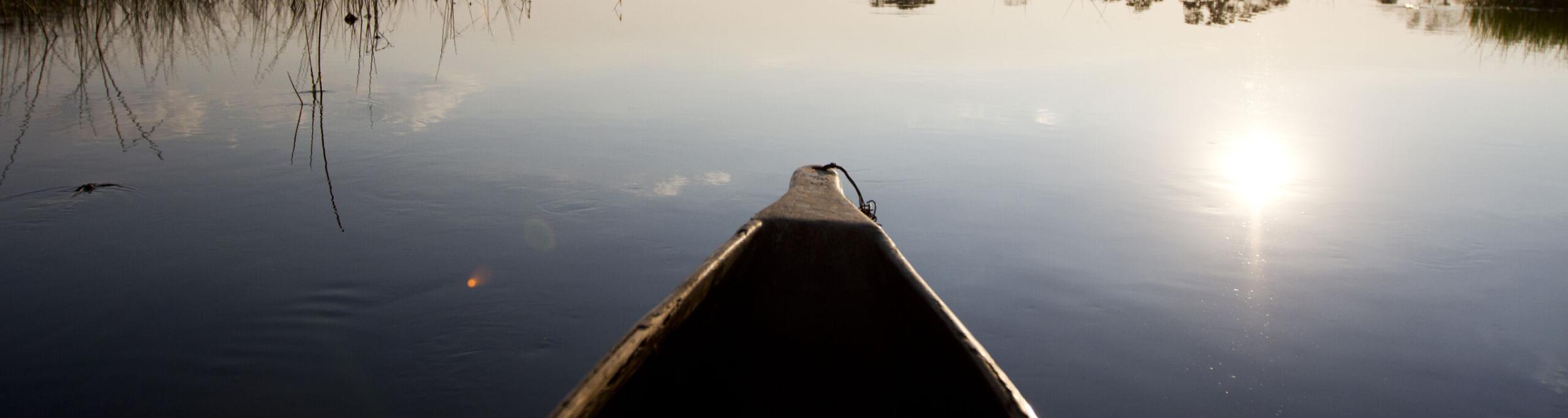 A canoe paddles on a lake.