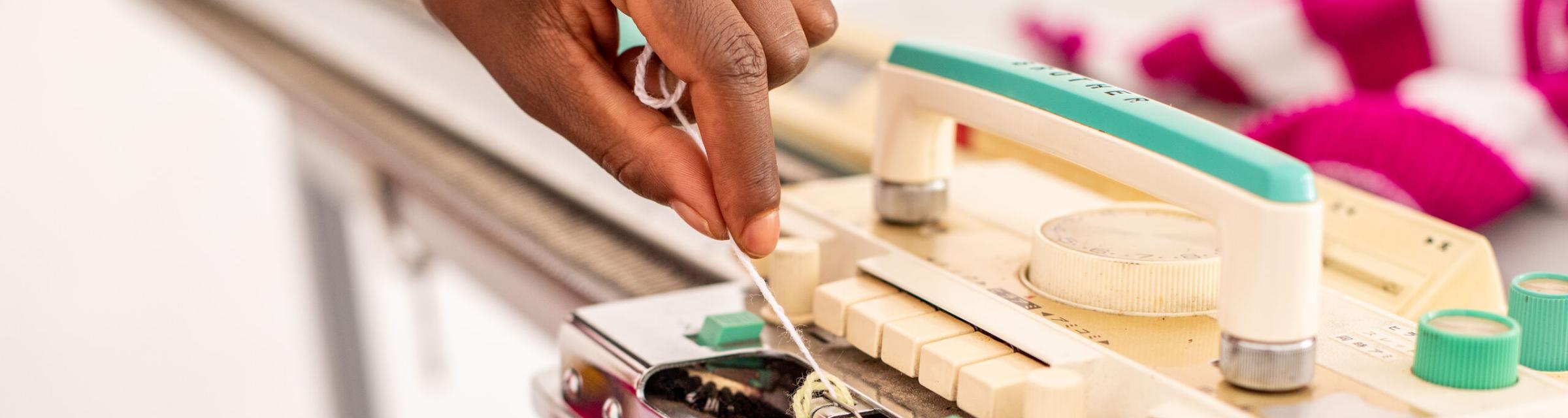A woman working on a knitting machine in north-central Africa. Photo by RJ Rempel.