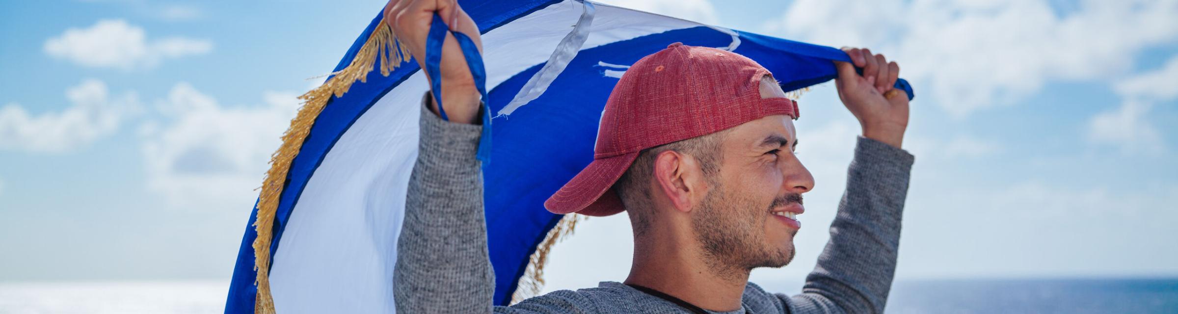 OM Ships :: Jareht Gradiz (Nicaragua) waves his national flag on the outer deck of Logos Hope.