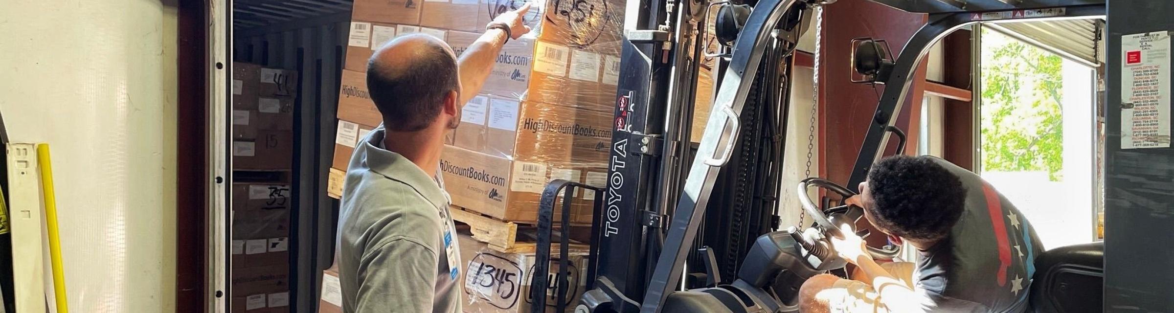 OM Ships :: Sales Representative Stephen Lipham (left) and Florence Warehouse Manager Ross Goodknight (right) load pallets of books to be shipped to ministry partners around the world.