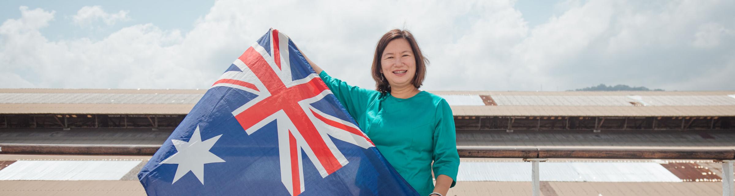 OM Ships :: Frances Win (Australia) shows her Australian flag while wearing the Burmese traditional costume as she grew up in Myanmar (previous Burma) but moved with her family to Australia when she was in he 20s and considers herself Australian.