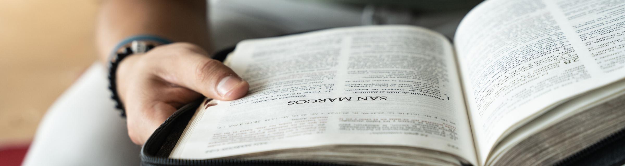 A man flips through a Spanish Bible. Photo by RJ Rempel