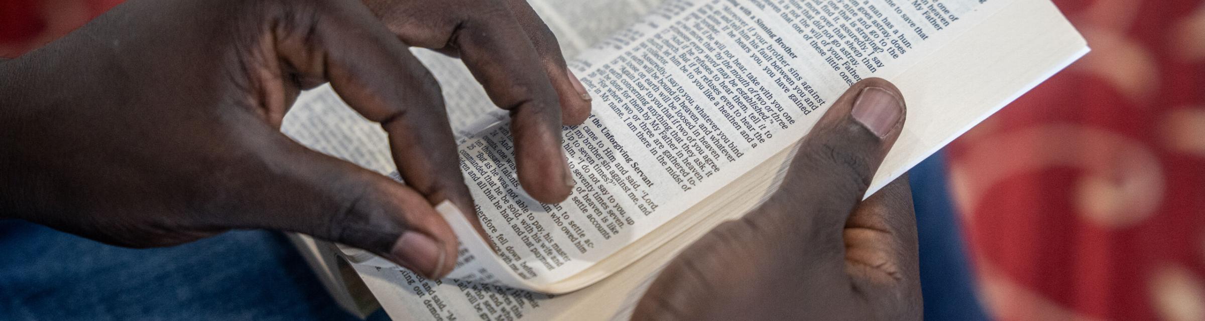 A man flips through the Bible. Photo by RJ Rempel.