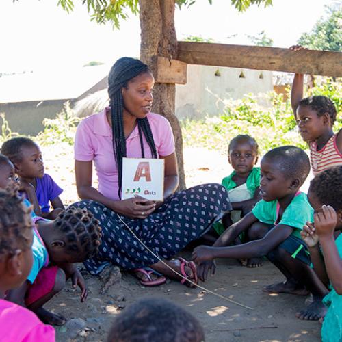 young woman teaching a group of students in Africa