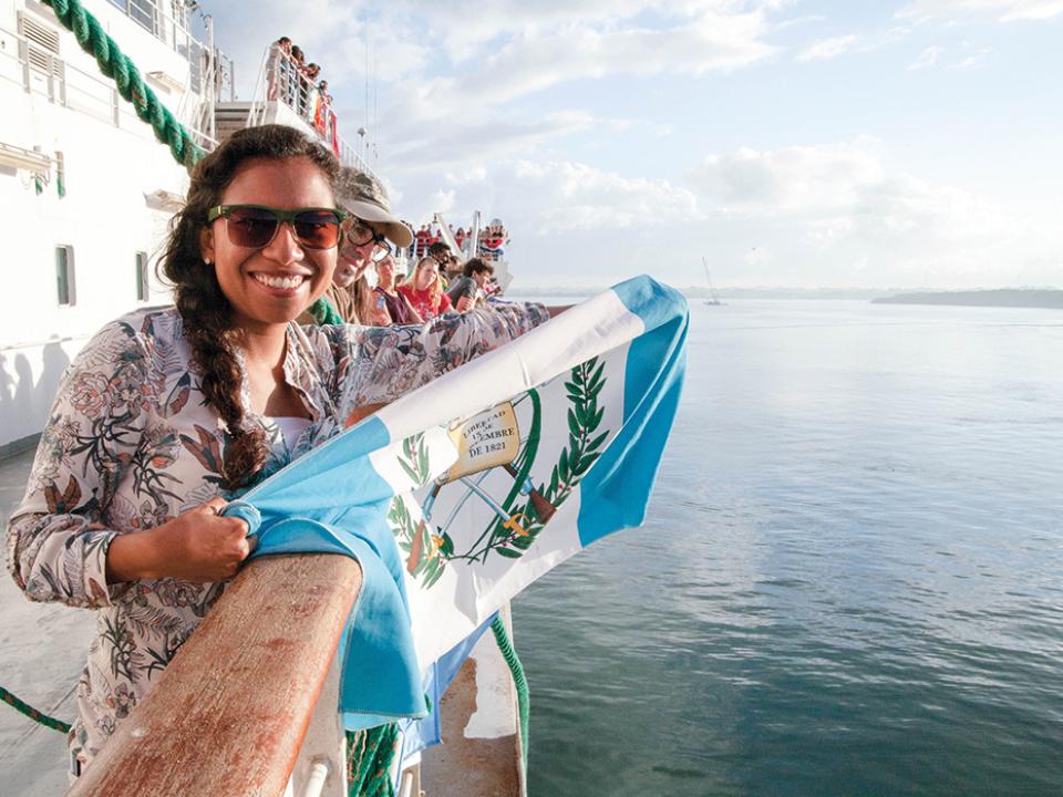 young woman holds flag onboard the Logos ship