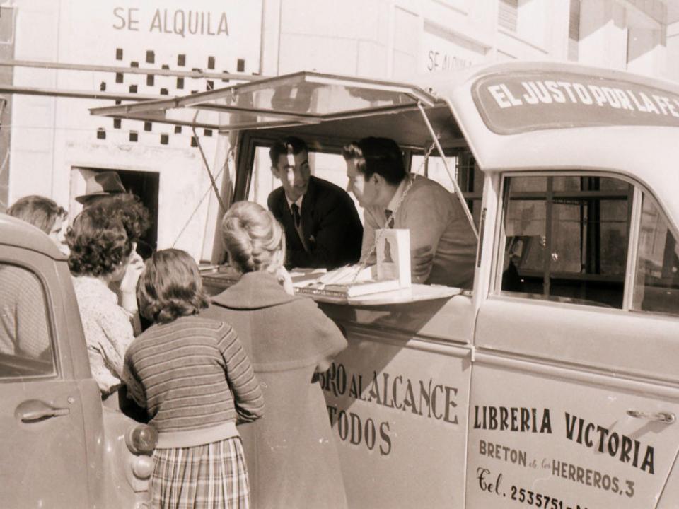 Literature is distributed from a van in 1960 Spain