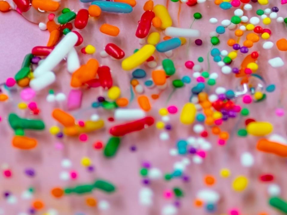 Bunte Bonbons und andere Teilchen auf rosa Hintergrund