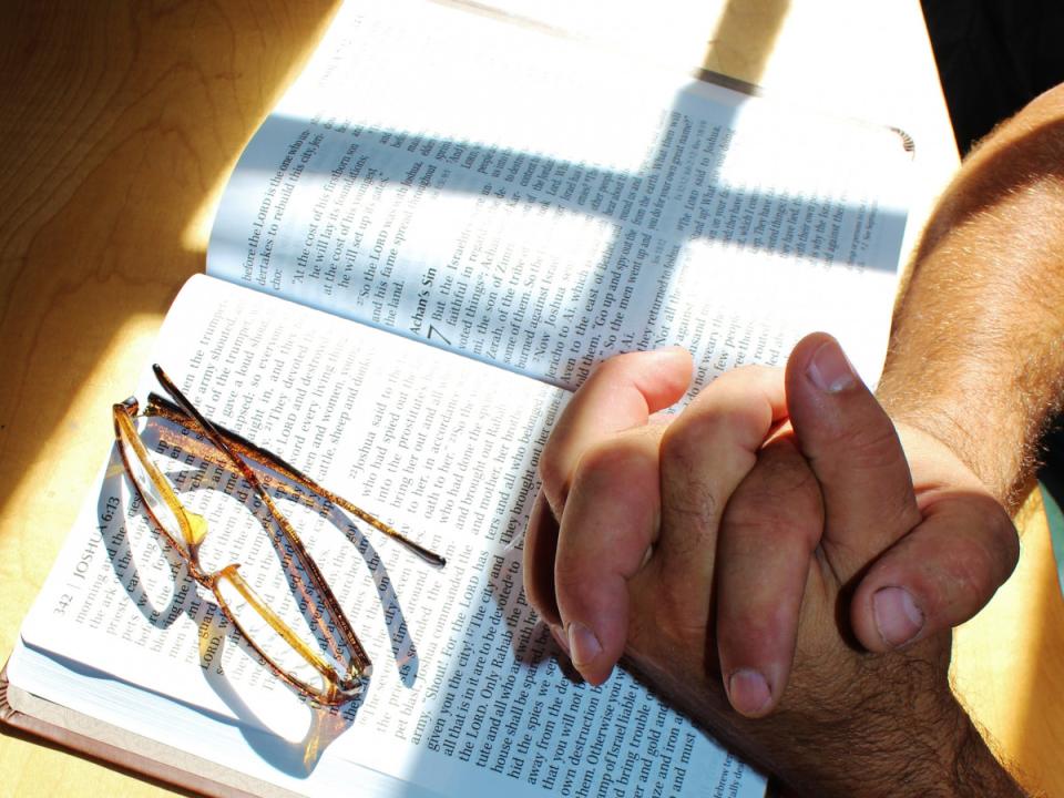 mani in preghiera sopra una bibbia