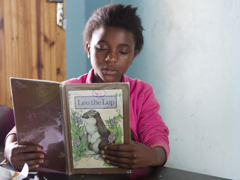 A student reads at Mercy House in Kabwe, Zambia. Photo by Rebecca Rempel.