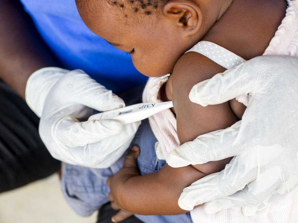 A nurse checks a baby's temperature at a medical clinic in Chipwa, Zambia. The OM Lake Tanganyika team, in partnership with the Zambian government, hold medical clinics in villages along the lake where health care is not readily available.