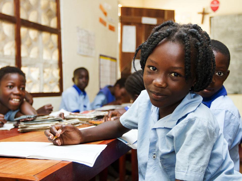 A student looks up from her work at the Good News School II for orphaned and vulnerable children in Mpulungu, Zambia.