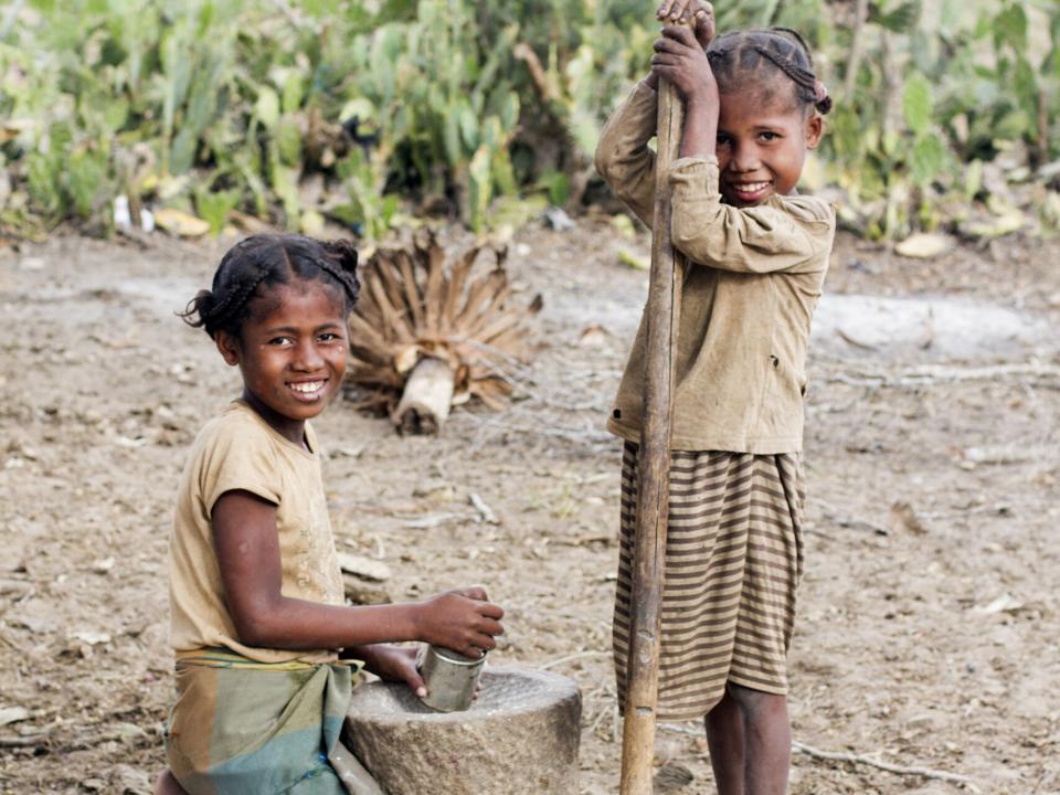 Two girls pound cassava in a village outside of Ambovombe, Madagascar.