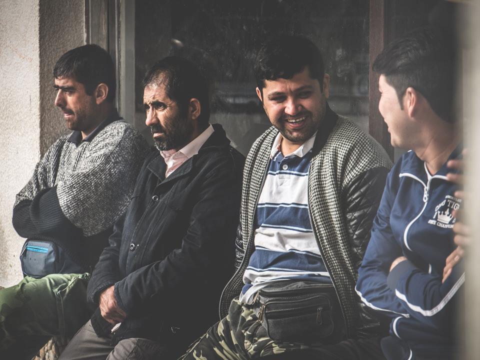 men chatting at the refugee camp in Sid, Serbia