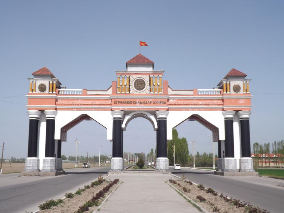 A monumental gateway stretches over a road in ex-Soviet Central Asia.