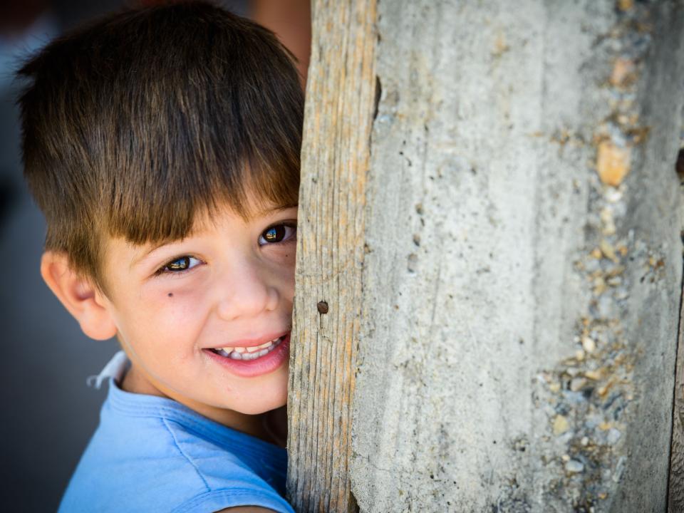 A young gypsy or roma boy shyly posses for his picture during a house church meeting in a Romanian gypsy village.