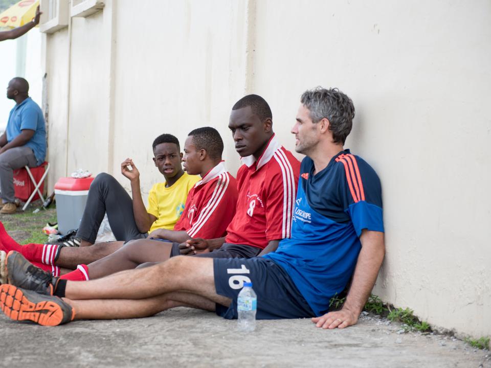 Castries, St. Lucia :: Luke Thomas (USA) talks to players at a football tournament.