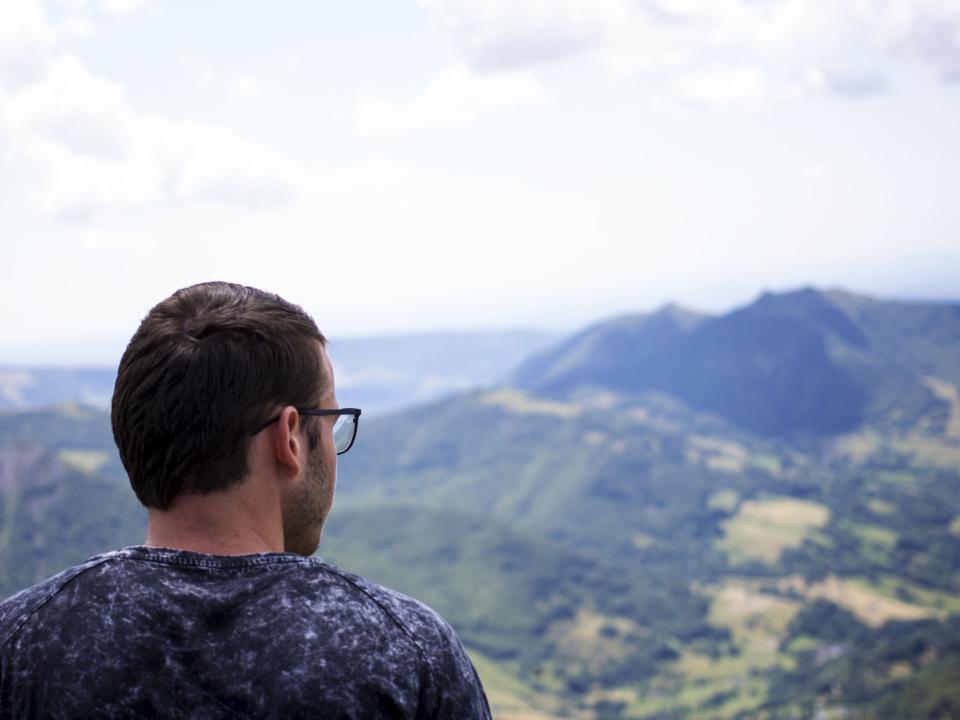 Norwegian young man sits and stares at God's creation on top of Puy Mary in the Cantal Region of France.