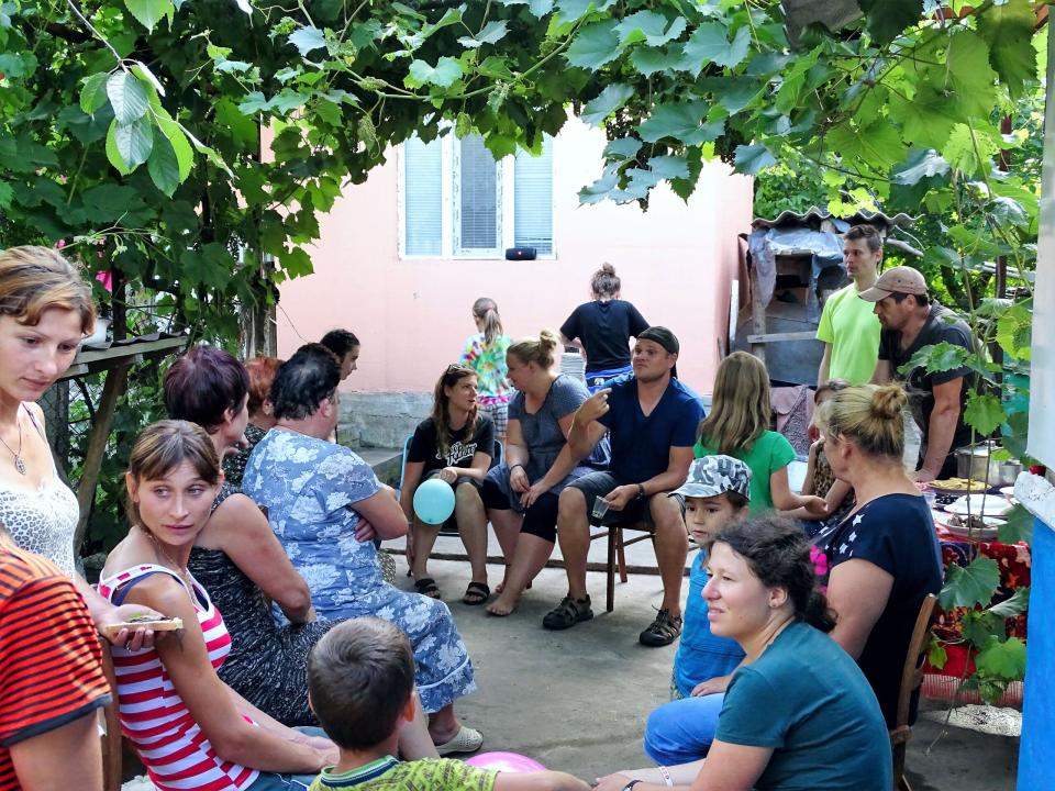 Members of an outreach team continue discussing with local villagers after leading an evangelistic event at the home of the only believer in the community, whom God had led them to by a “chance” meeting.