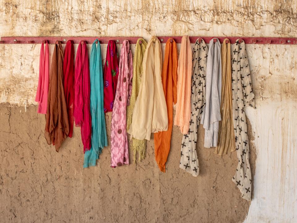 Head scarves hang on a row of pegs. Photo by Rebecca Rempel.