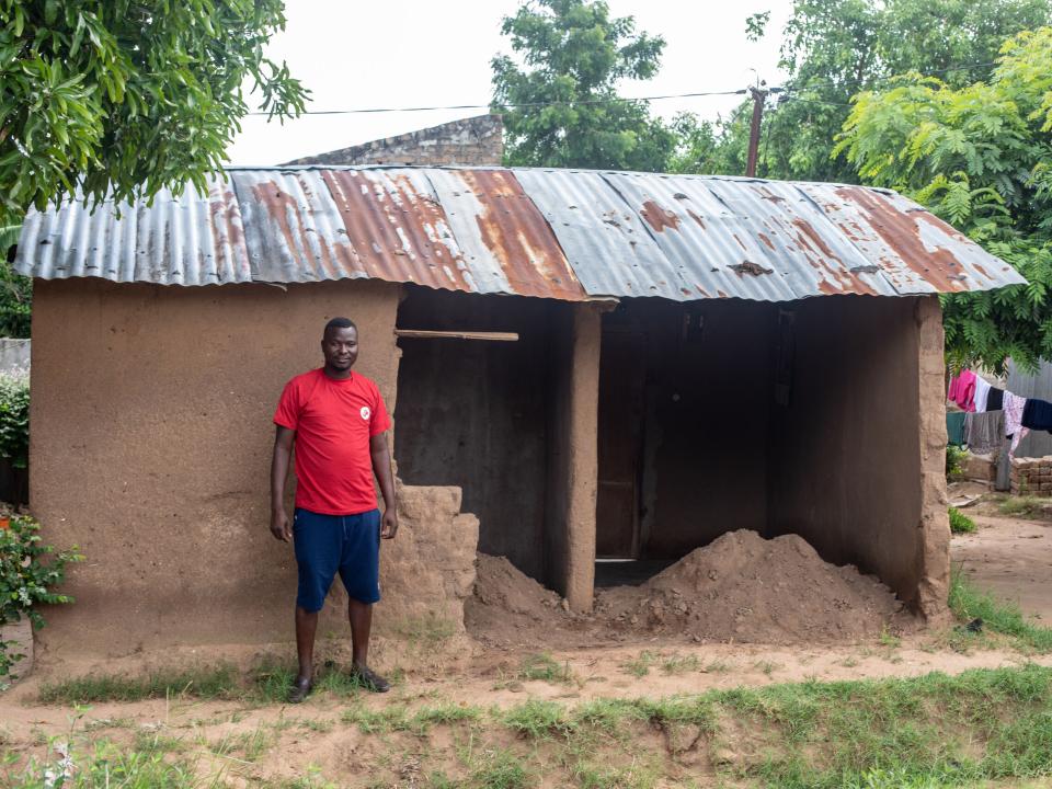 OMer Estavao stands outside of his home in Mozambique. The back wall collapsed during the rains of Cyclone Idai. Photo by Rebecca Rempel