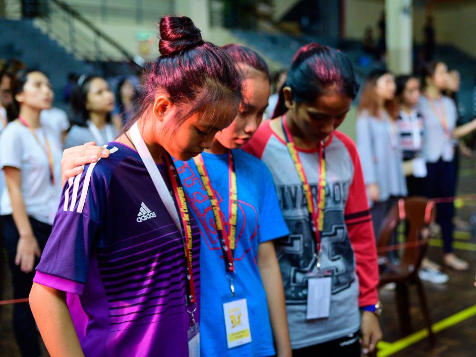 3 girls praying together at the opening ceremony