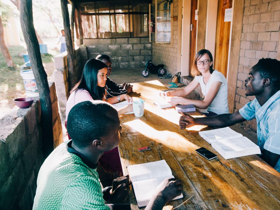 Ivy, in the striped shirt on the left, does a Bible study at Lake Tanganyika. Photo by Doseong Park.