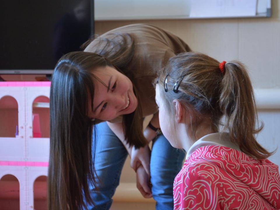 A staff member joyfully interacts with a young girl from unreached village, sharing the love of God with her.