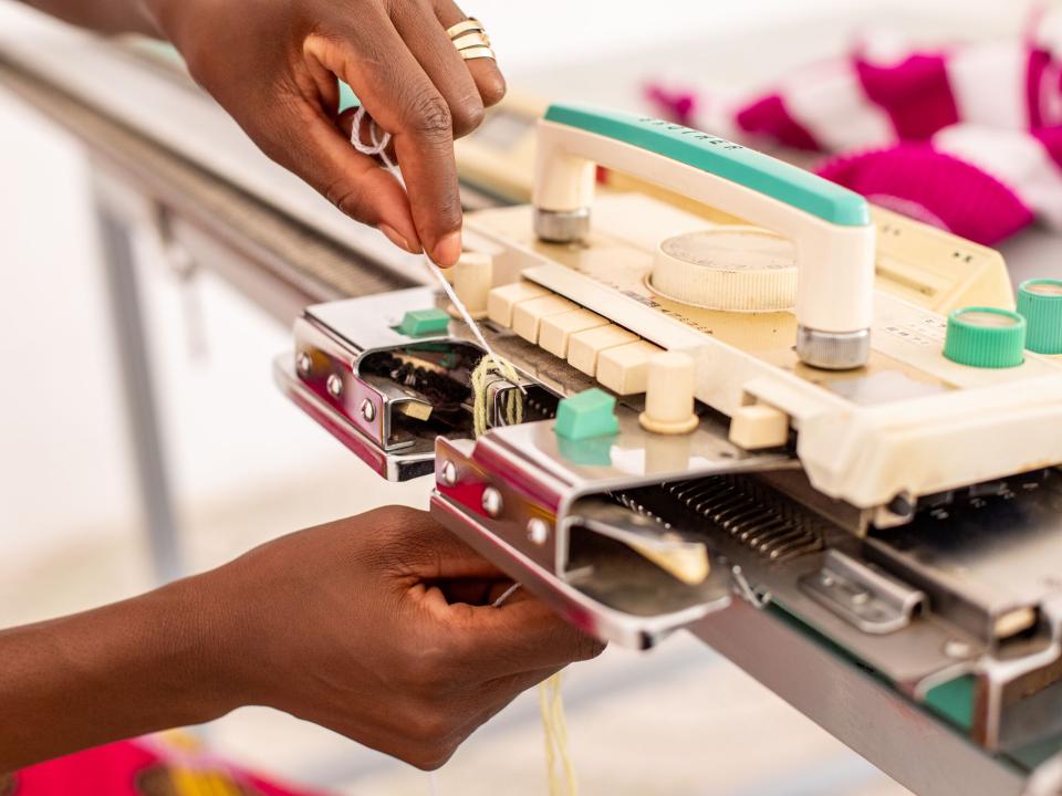 A woman working on a knitting machine in north-central Africa. Photo by RJ Rempel.