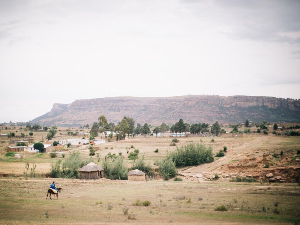 Man on a donkey arrives at his village in Lesotho. Lesotho is a small mountainous country completely surrounded by South Africa. Photo by Doseong Park.
