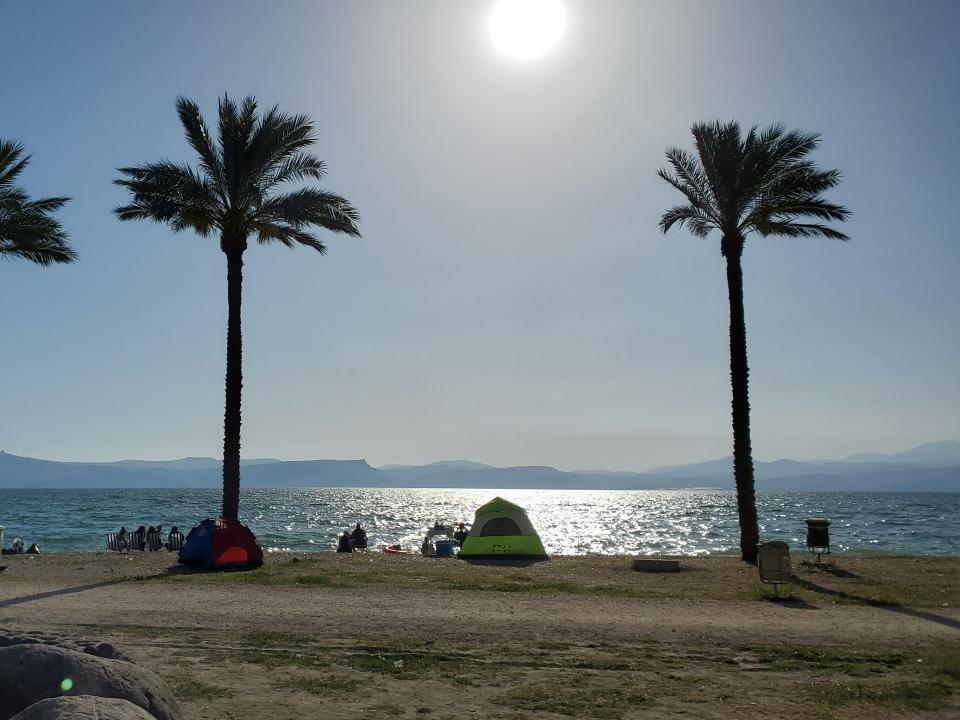 People camping and enjoying the shore of a sunny, Israel day. Photo by Thomas.