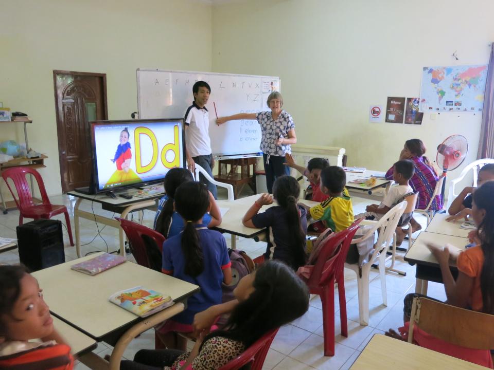 In their mid-sixties Kiwis Pam and Alan retired. Sort of. “You don’t retire and suddenly that’s it,” Alan explained. “You just continue on involved in the Kingdom but with some changes.” Pictured is Pam helping teach English in Cambodia. Photo submitted b