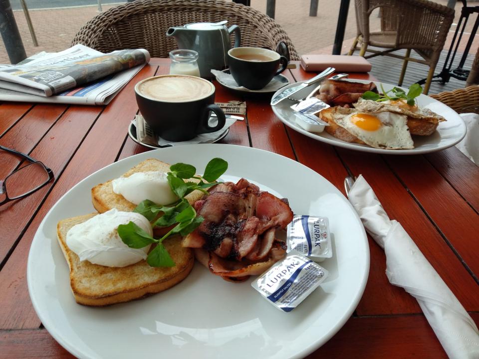 Richard enjoys bacon and eggs with coffee at an Adelaide cafe by the beach.