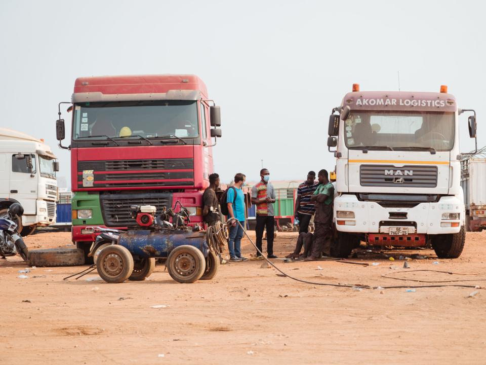 Tema, Ghana :: Logos Hope crewmember conversing with truck drivers near the port.