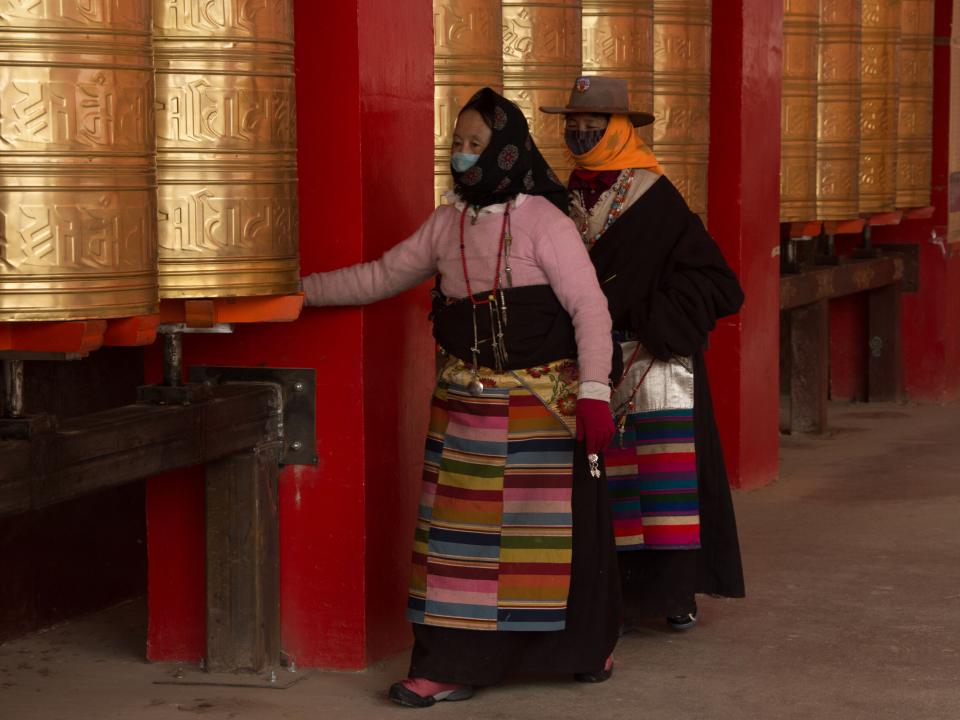 Walking around a prayer wheel is a common Tibetan religious activity. The Tibetan female monks pictured here are making their rounds around a series of golden prayer wheels as part of their daily routine. Photo by Ellyn Schellenberg.
