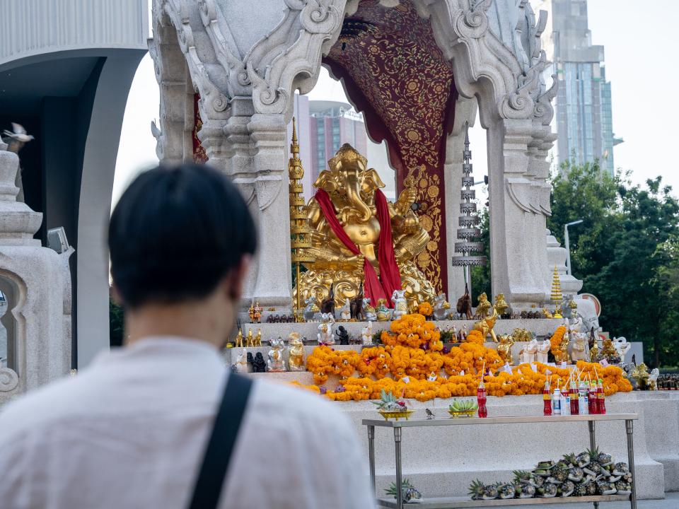 Man praying at a Buddhist shrine in Thailand. Photo by Rebecca Rempel.