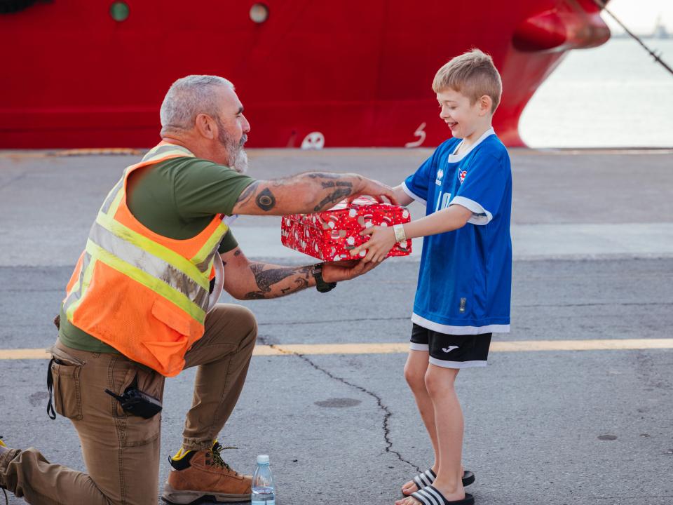 Limassol, Cyprus :: Logos Hope School child delivers Christmas gift to marine services worker.