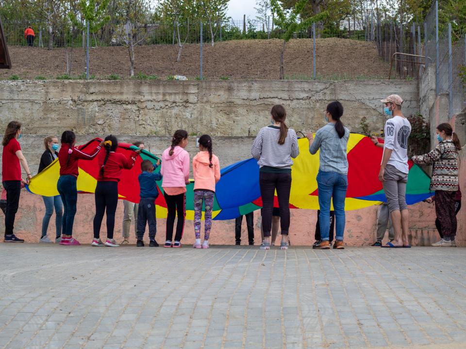 Participants of REACH in Moldova and Romania playing with children while on an outreach in Moldova.
