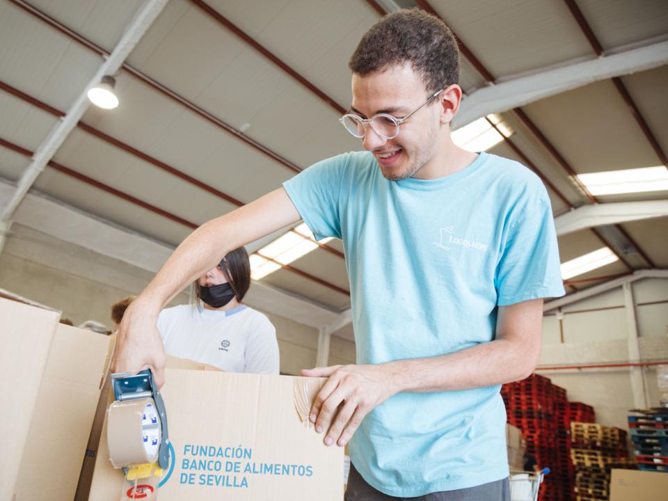 Seville, Spain :: Lucas Brito (Spain/Brazil) helps a food organization by packing the foods.