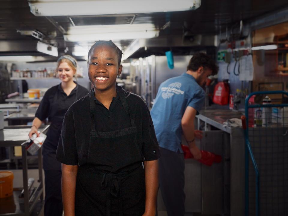 Vlorë, Albania :: Abigail (Zimbabwe) smiles for a photo during a shift on board Logos Hope in the galley