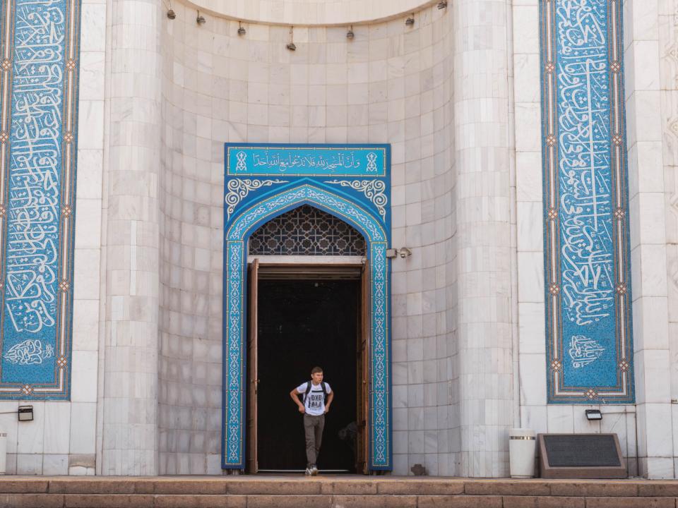 General view of a man walking out of a Mosque in Central Asia. Photo by Adam Hagy.