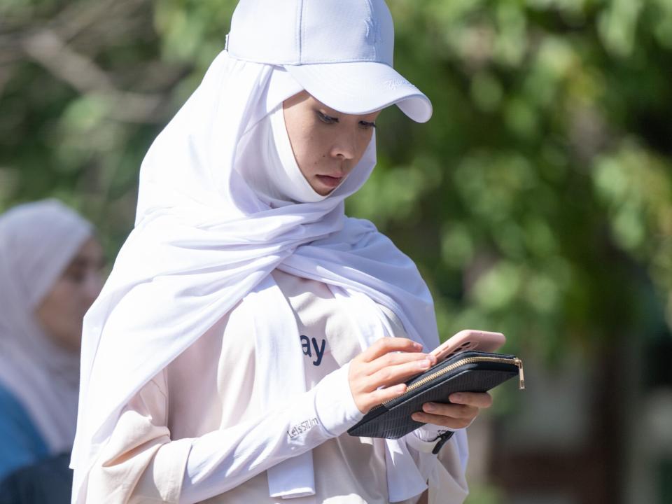 Central Asian woman looks at her phone. Photo by Adam Hagy.