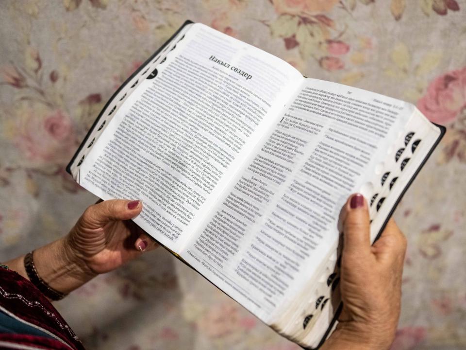 Traditional Central Asian woman holds Bible in her hands. Photo by Adam Hagy.