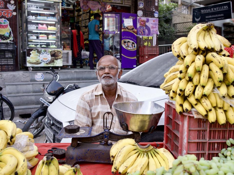 People in South Asia. A street vendor selling fruit in a busy street in South Asia.