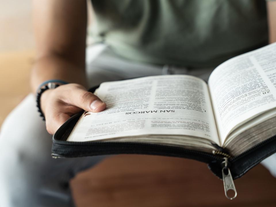 A man flips through a Spanish Bible. Photo by RJ Rempel